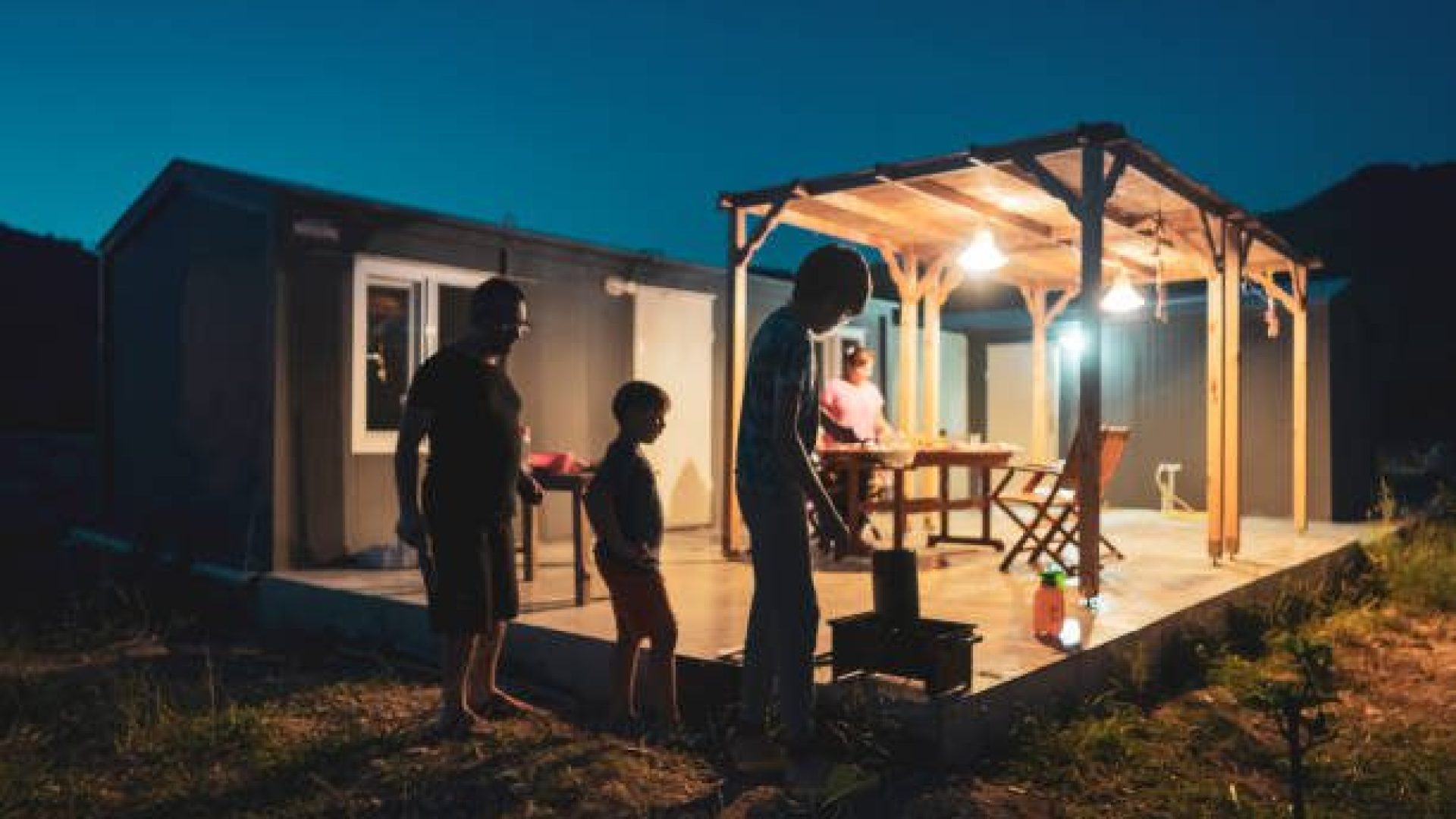 Happy kids enjoying in BBQ night with their father in the backyard.